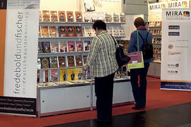 Women are standing in front of a book stand