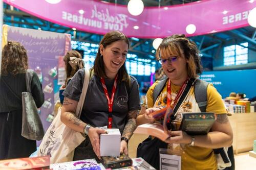 Zwei Besucherinnen freuen sich über Bücher und Goodies auf der Frankfurter Buchmesse.