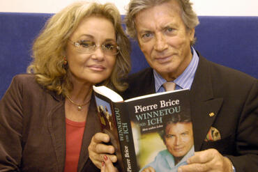 Schauspieler Pierre Brice und seine Frau Hella posieren am Freitag, 21. Oktober 2005, auf der Frankfurter Buchmesse mit dem Bu