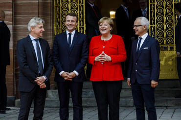 From left to right: Jürgen Boos, Director of Frankfurter Buchmesse, French President Emmanuel Macron, German Chancellor Angela Merkel and Heinrich Riethmüller, Head of the German Publishers & Booksellers Association, in front of the fair’s Festhalle