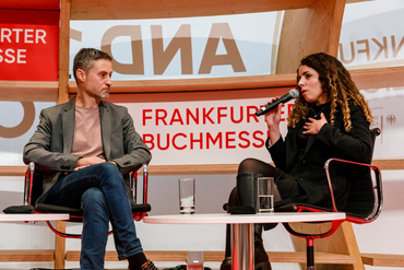 Zwei bekannte Persönlichkeiten reden auf der Bühne im Pavillon
