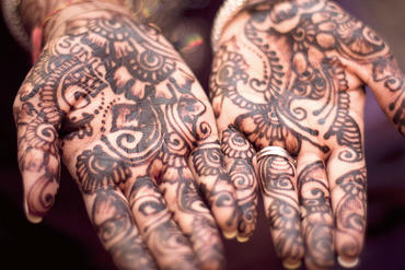 Two hands painted with henna paint