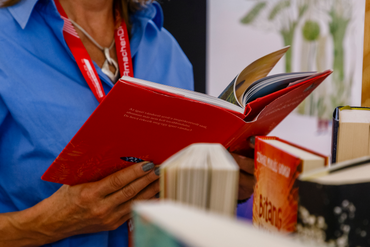 Hände, die ein aufgeschlagenes Buch halten.