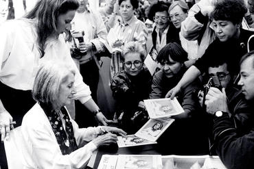 Woman gives autograph to journalists