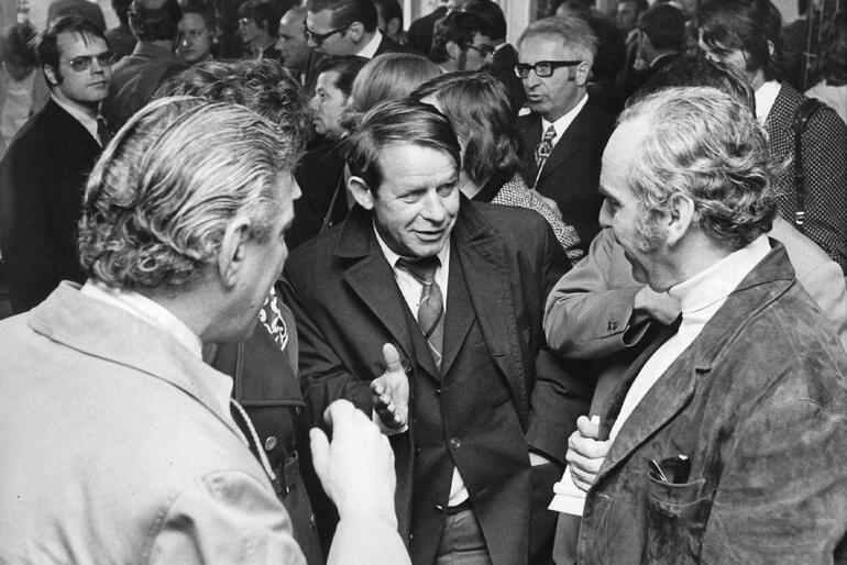 Schriftsteller Siegfried Lenz (M.) und damaliger Verlagsleiter  Albrecht Knaus (r) unterhalten sich am 1971 im Dominikaner-Kloster in Frankfurt am Main bei einem Empfang des Verlages Hoffmann und Campe.
