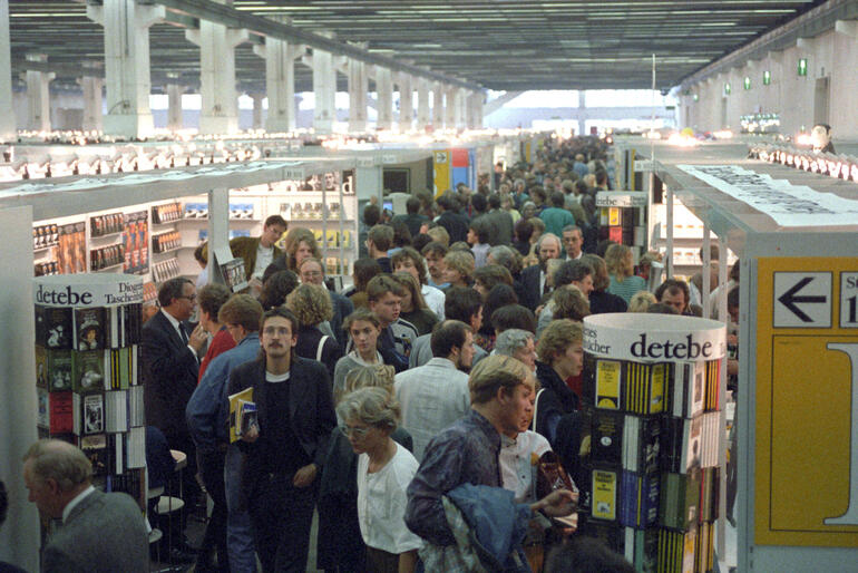 Crowds of visitors in an aisle between fair stands in 1989