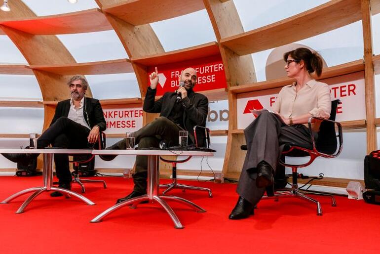 Panelisten auf der Bühne in einem Gespräch.