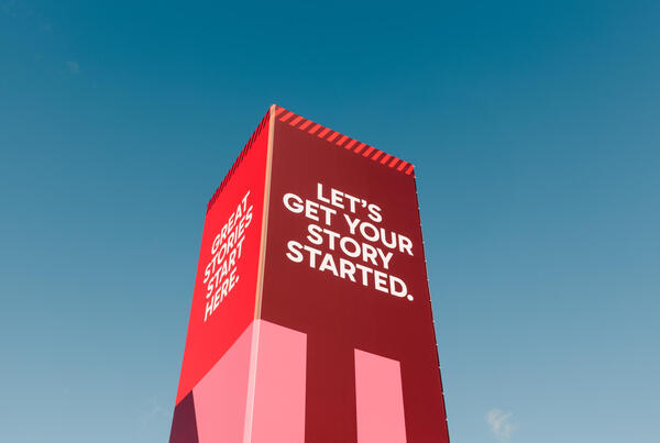 Foto von einem Werbeturm der Frankfurter Buchmesse auf dem "Let's get your story started" steht.