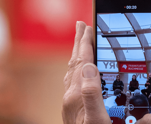 Eine Veranstaltung wird auf einem Smartphone mitgefilmt.