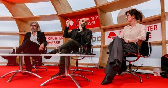 Panelisten auf der Bühne in einem Gespräch.
