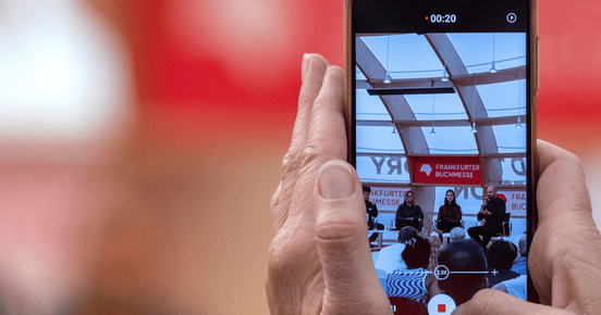 Eine Veranstaltung wird auf einem Smartphone mitgefilmt.
