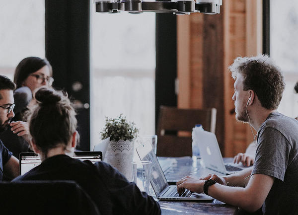 Eine Gruppe von Menschen arbeitet konzentriert an ihren Laptops
