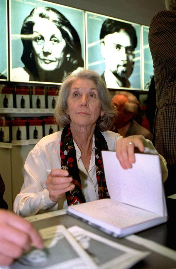A woman at a Frankfurter Buchmesse stand reads “The Satanic Verses” by British-Indian writer Salman Rushdie