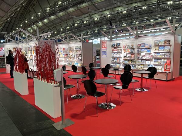 Exhibition stand with bookshelves and seating area