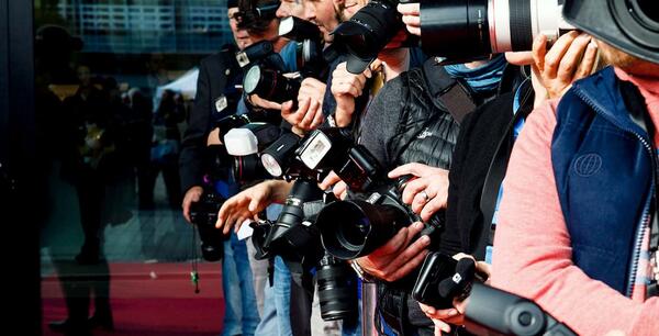 Paparazzi standing in front of hall and wait for stars