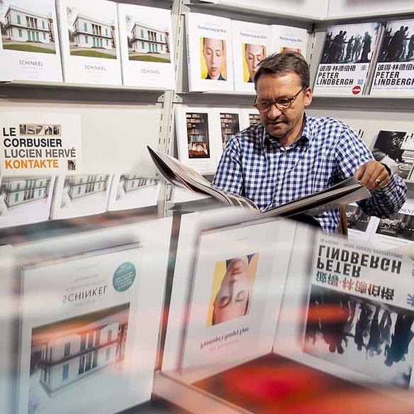 Mann liest in aufgeschlagenen Kunstbüchern
