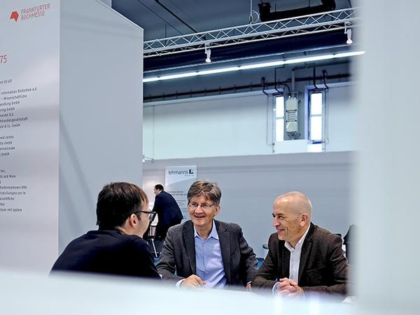 Drei Männer unterhalten sich am ILC Stand