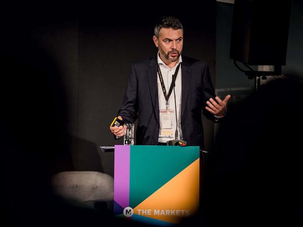 Mann hält Vortrag auf Business Conference the Markets Bühne