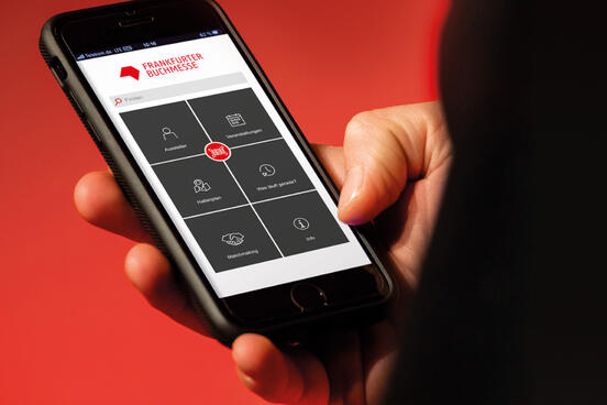 Hand holding cell phone with Buchmesse app open