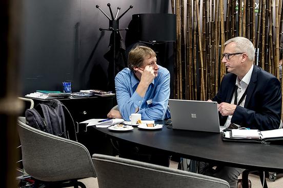 Zwei Männer unterhalten sich vor einem Computer
