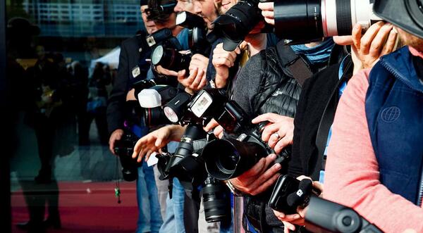 Paparazzi standing in front of hall and wait for stars