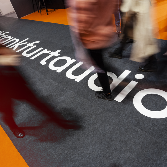 Personen laufen über Teppich mit Frankfurt Audio Branding