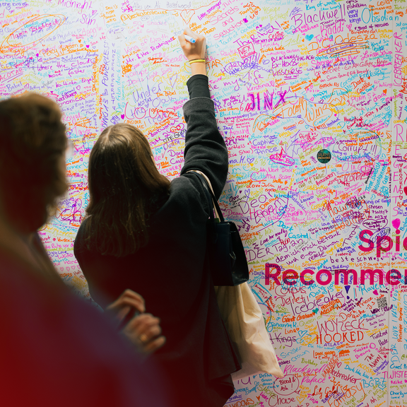 Frau schreibt auf Signierwand