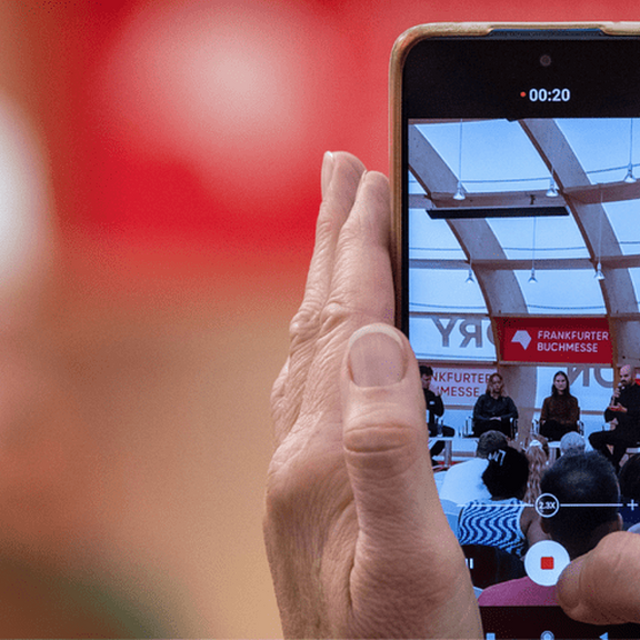 Eine Veranstaltung wird auf einem Smartphone mitgefilmt.