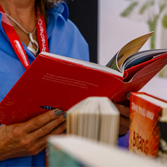 Hände, die ein aufgeschlagenes Buch halten.