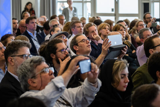 Visitors of Frankfurter Buchmesse taking photos at a conference