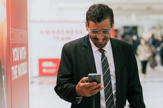 Fachbesucher mit Handy auf der Buchmesse
