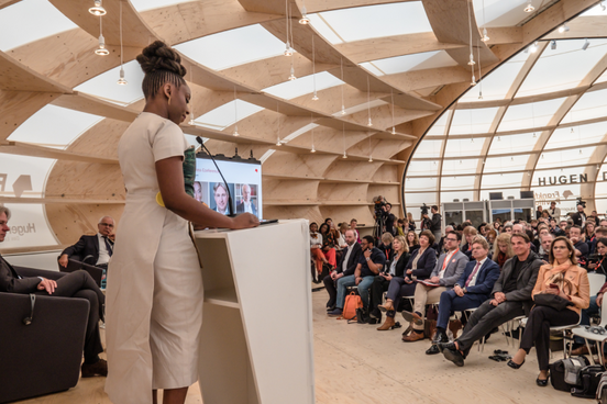 Frau redet auf Bühne im Pavillon