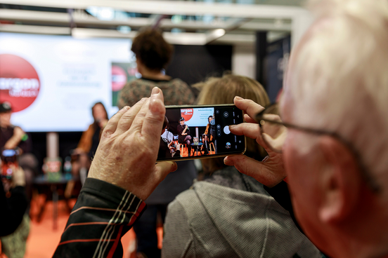 Mann nimmt Bühnensituation mit dem Handy auf