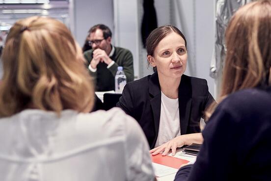 Eine Frau im Gespräch mit zwei anderen Frauen auf der Frankfurter Buchmesse.