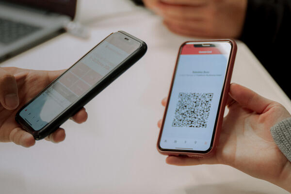Ein Smartphone scannt das Handyticket auf einem anderen Smartphone