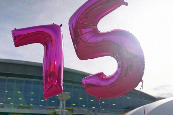 Luftballons in Form einer 7 und 5 fliegen am Himmel